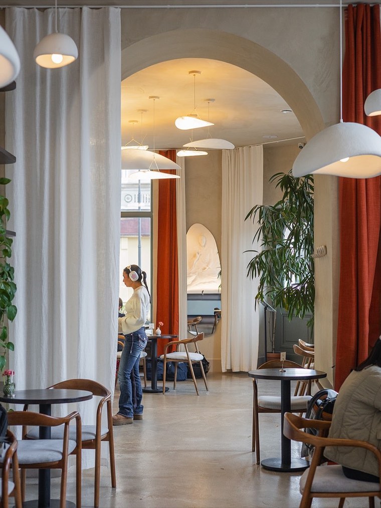 Auro Café interior with tall windows and orange curtains