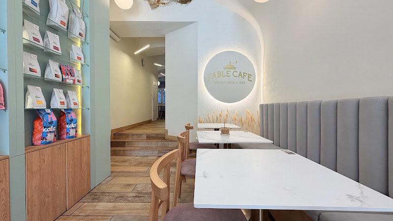 Fable Cafe dining room with white tables and a long banquette