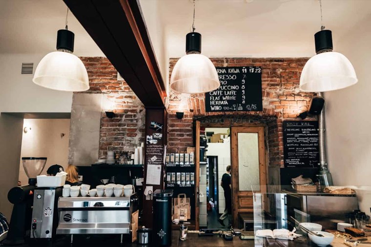 Karma Cafe counter with pendant lamps and a brick wall
