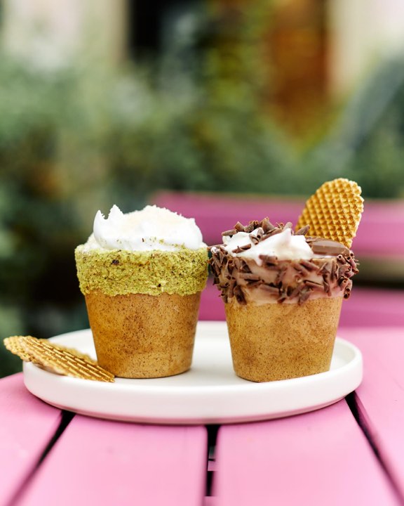 Two cream-topped desserts in wafer cups